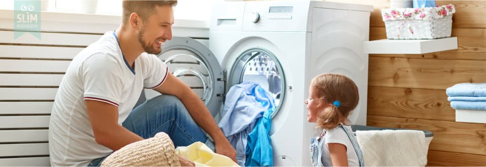 Vader en dochter vullen samen de wasmachine