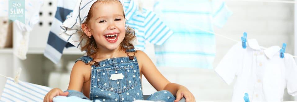 Vrolijk meisje met bandana zit in een wasmand