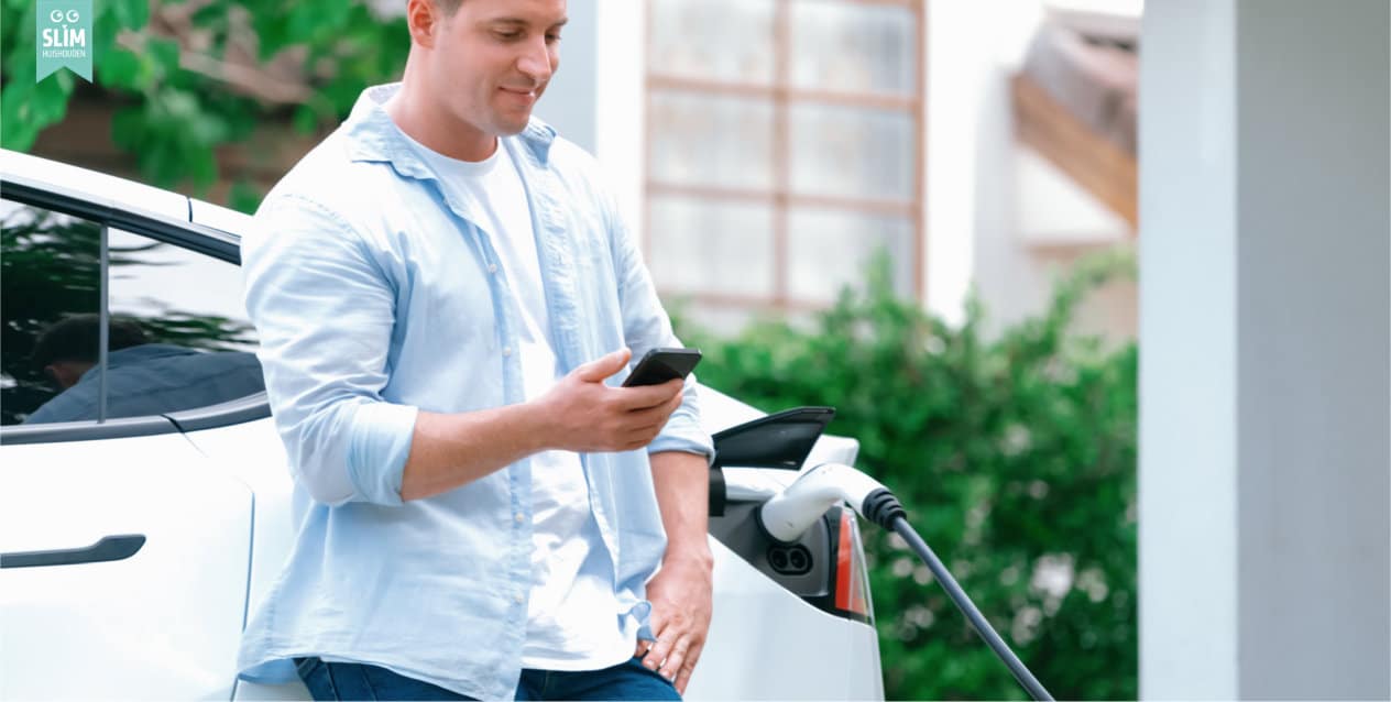Auto wordt opgeladen man met telefoon 2024 Shutterstock_2372325323