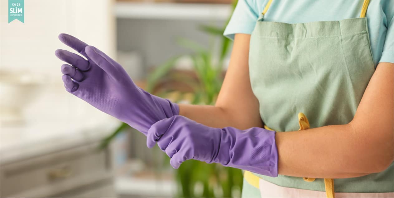 Vrouw trekt paarse schoonmaakhandschoenen  aan